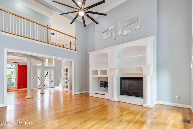 15108 Chestnut Ridge Cir, Louisville, KY 40245 - unfurnished living room featuring wood finished floors, a high ceiling, ornate columns, a ceiling fan, and baseboards