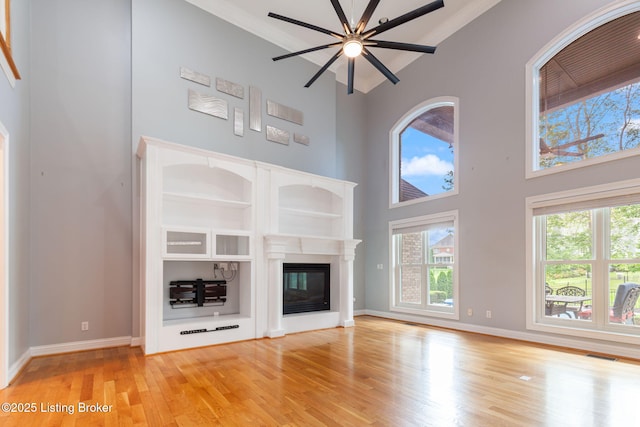 15108 Chestnut Ridge Cir, Louisville, KY 40245 - unfurnished living room featuring a ceiling fan, light wood-style flooring, healthy amount of natural light, a towering ceiling, and ornamental molding
