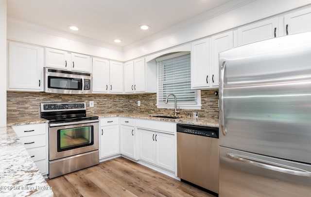 922 Fenley Ave, Louisville, KY 40222 - kitchen featuring appliances with stainless steel finishes, a sink, white cabinets, crown molding, and light wood-style flooring