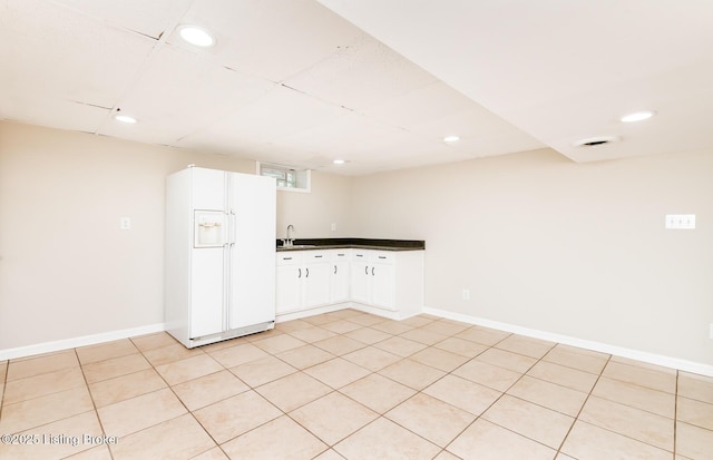 922 Fenley Ave, Louisville, KY 40222 - kitchen with white fridge with ice dispenser, dark countertops, a sink, white cabinetry, and recessed lighting