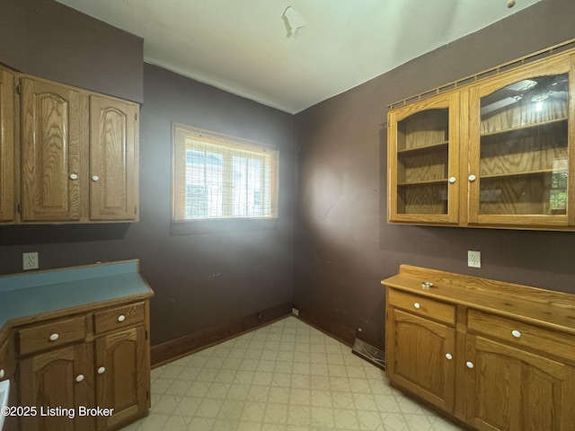 816 Highland Ave, Carrollton, KY 41008 - kitchen with light floors, baseboards, glass insert cabinets, and brown cabinets