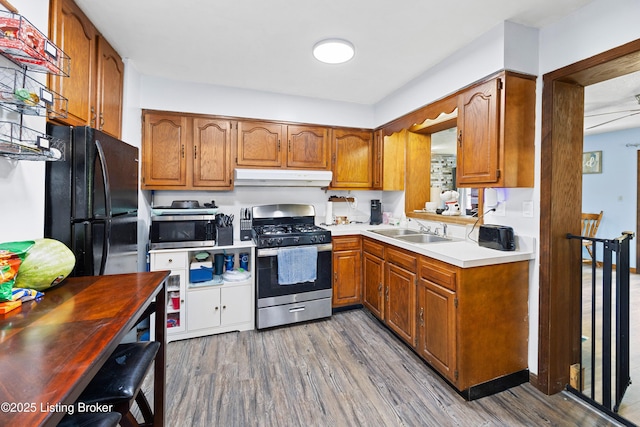 10608 Charlene Dr, Fairdale, KY 40118 - kitchen with stainless steel appliances, under cabinet range hood, a sink, and brown cabinetry