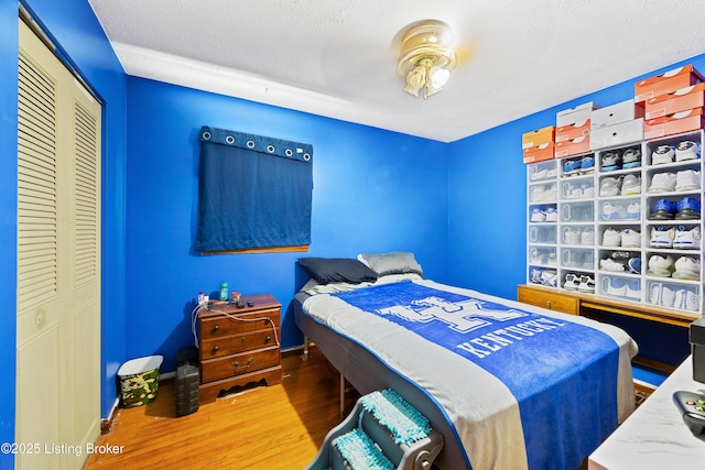 10608 Charlene Dr, Fairdale, KY 40118 - bedroom with wood finished floors, a closet, a textured ceiling, and baseboards