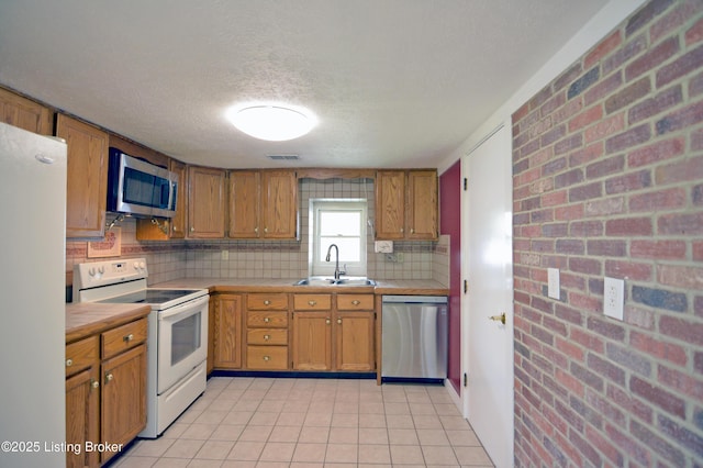 8201 Damascus Rd, Louisville, KY 40228 - kitchen with stainless steel appliances, a sink, a textured ceiling, brown cabinets, and decorative backsplash