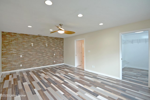 8201 Damascus Rd, Louisville, KY 40228 - unfurnished bedroom featuring brick wall, recessed lighting, wood finished floors, baseboards, and a spacious closet