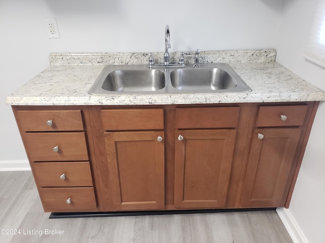 1020 Stanley Ave, Louisville, KY 40215 - kitchen featuring a sink, light wood-style floors, brown cabinets, and light stone countertops