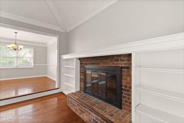 12409 Ledges Dr, Louisville, KY 40243 - detailed view of crown molding, a brick fireplace, wood finished floors, a chandelier, and built in shelves