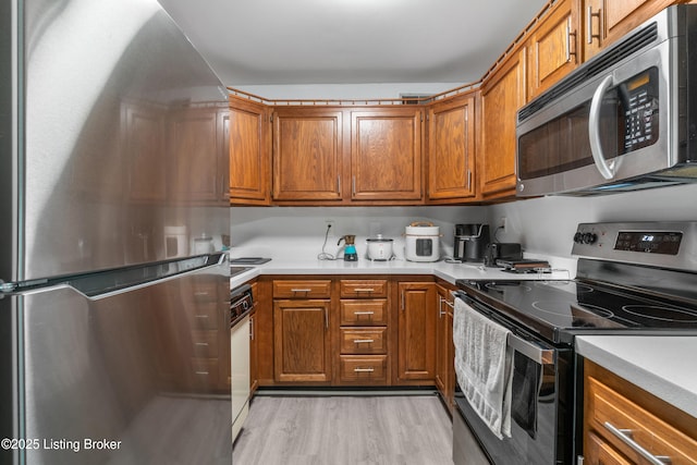 10 Dupont Way Unit 6, Louisville, KY 40207 - kitchen with stainless steel appliances, brown cabinets, light countertops, and light wood finished floors