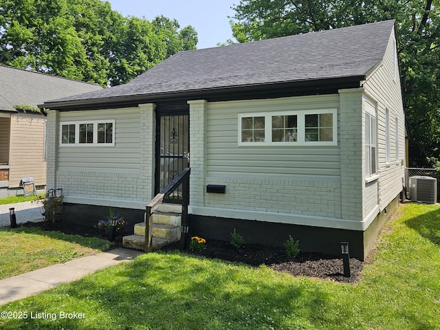 1165 Lincoln Ave, Louisville, KY 40208 - view of front facade with central AC unit, a front lawn, entry steps, and brick siding