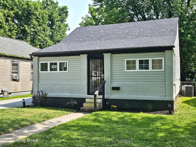 1165 Lincoln Ave, Louisville, KY 40208 - view of front facade with cooling unit, a front yard, roof with shingles, and brick siding