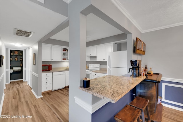 1008 Lake Way Unit D12, Louisville, KY 40222 - kitchen with white appliances, white cabinets, light wood-style floors, a breakfast bar, and a peninsula