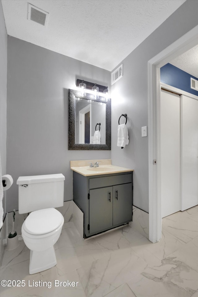 1008 Lake Way Unit D12, Louisville, KY 40222 - bathroom featuring vanity, toilet, marble look tiles, and a textured ceiling