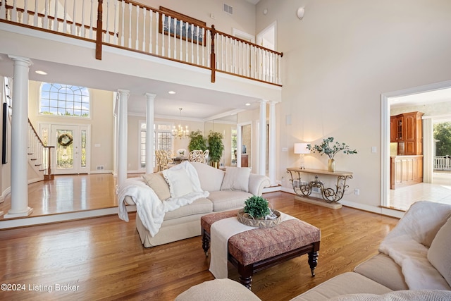 14702 Forest Oaks Dr, Louisville, KY 40245 - living area featuring a towering ceiling, decorative columns, light wood finished floors, baseboards, and stairway