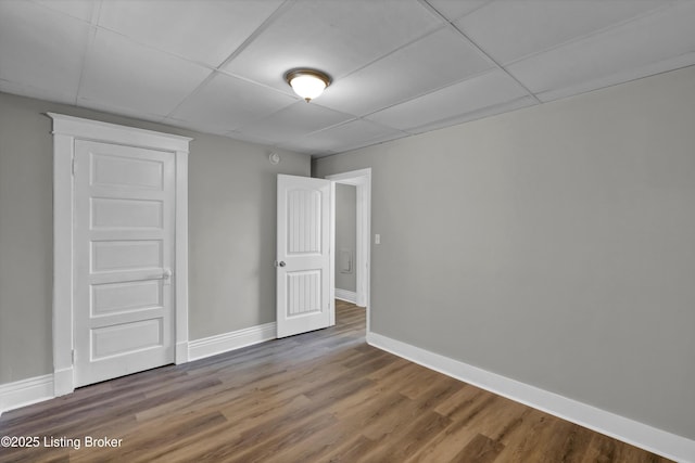 209 W Kenton St, Louisville, KY 40214 - unfurnished bedroom featuring a drop ceiling, baseboards, and wood finished floors
