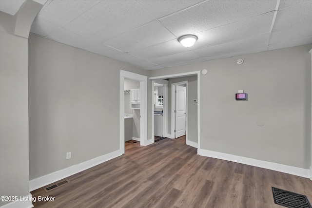 209 W Kenton St, Louisville, KY 40214 - unfurnished room featuring a drop ceiling, baseboards, and dark wood-style floors