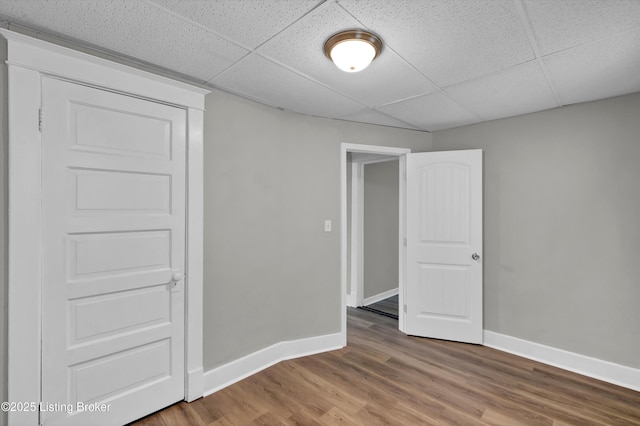 209 W Kenton St, Louisville, KY 40214 - spare room with a drop ceiling, baseboards, and wood finished floors