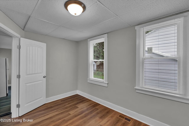 209 W Kenton St, Louisville, KY 40214 - unfurnished room with a paneled ceiling, dark wood-style flooring, and baseboards