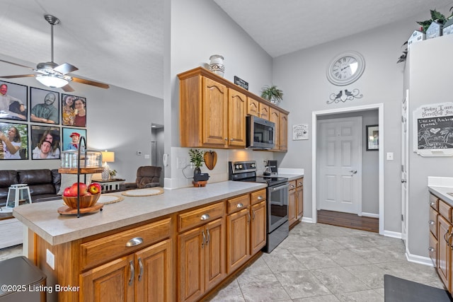 8506 Hunting Stock Pl, Louisville, KY 40291 - kitchen with appliances with stainless steel finishes, light countertops, brown cabinets, a ceiling fan, and a peninsula