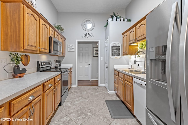 8506 Hunting Stock Pl, Louisville, KY 40291 - kitchen with stainless steel appliances, a sink, light countertops, light tile patterned flooring, and brown cabinets