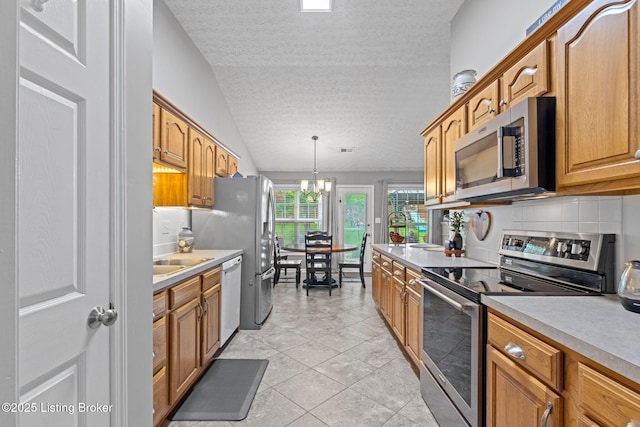 8506 Hunting Stock Pl, Louisville, KY 40291 - kitchen with appliances with stainless steel finishes, a textured ceiling, light countertops, a chandelier, and pendant lighting