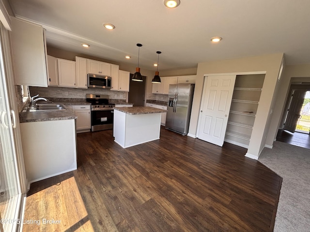 373 University Dr, Walton, KY 41094 - kitchen featuring stainless steel appliances, decorative backsplash, a kitchen island, dark countertops, and white cabinetry