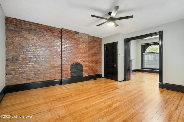 965 S Shelby St, Louisville, KY 40203 - unfurnished living room with light wood-style floors, a brick fireplace, a ceiling fan, baseboards, and brick wall