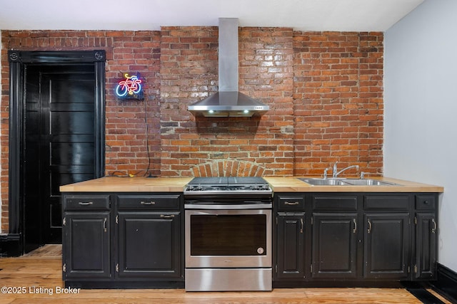 965 S Shelby St, Louisville, KY 40203 - kitchen with stainless steel range, wall chimney exhaust hood, a sink, dark cabinets, and light wood-style floors
