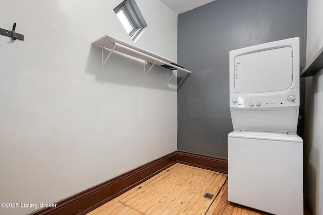 965 S Shelby St, Louisville, KY 40203 - laundry area featuring stacked washer and clothes dryer, light wood-style flooring, and baseboards