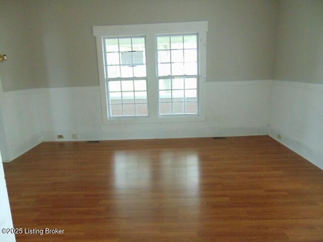 27 Alexander Ave, Bedford, KY 40006 - empty room featuring wainscoting and wood finished floors