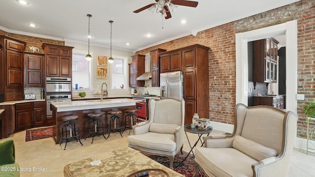 1212 S 2nd St, Louisville, KY 40203 - kitchen featuring appliances with stainless steel finishes, ceiling fan, light countertops, a kitchen breakfast bar, and ornamental molding