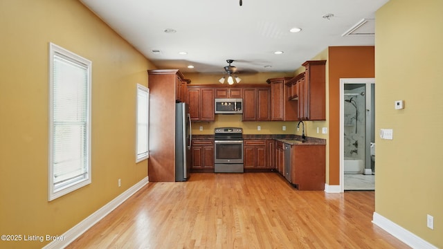 1212 S 2nd St, Louisville, KY 40203 - kitchen with appliances with stainless steel finishes, a ceiling fan, light wood-type flooring, dark countertops, and recessed lighting