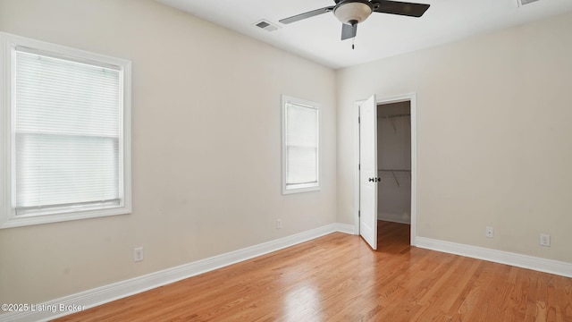 1212 S 2nd St, Louisville, KY 40203 - unfurnished bedroom featuring light wood-type flooring, a walk in closet, a closet, and ceiling fan