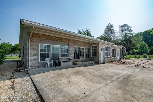 201 Wildflower Ln, Big Springs, KY 40175 - rear view of house with brick siding, a patio, metal roof, and a standing seam roof