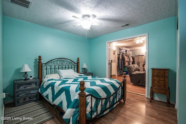 201 Wildflower Ln, Big Springs, KY 40175 - bedroom with wood finished floors, a walk in closet, a textured ceiling, ceiling fan, and a closet