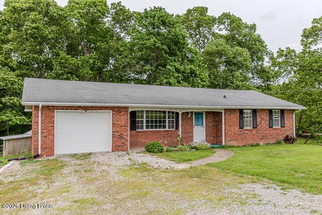 3110 Mount Lebanon Rd, Charlestown, IN 47111 - ranch-style home with a garage, brick siding, a front lawn, driveway, and view of scattered trees