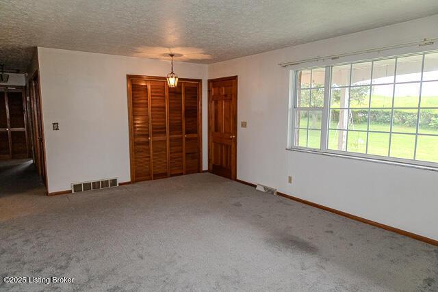 3110 Mount Lebanon Rd, Charlestown, IN 47111 - spare room featuring carpet, a textured ceiling, and baseboards