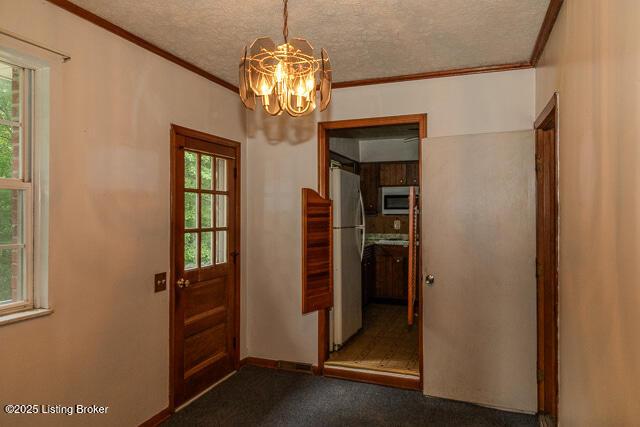3110 Mount Lebanon Rd, Charlestown, IN 47111 - doorway to outside with a chandelier, crown molding, a textured ceiling, dark carpet, and baseboards