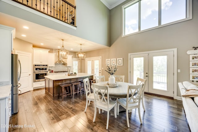 12406 Poplar Woods Dr, Goshen, KY 40026 - dining space with french doors, a towering ceiling, dark wood-type flooring, a chandelier, and crown molding