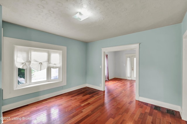 3707 Lentz Ave, Louisville, KY 40215 - empty room featuring hardwood / wood-style floors, baseboards, and a textured ceiling