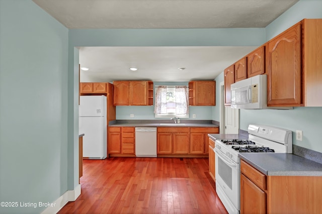 3707 Lentz Ave, Louisville, KY 40215 - kitchen featuring white appliances, a sink, open shelves, light wood-style flooring, and brown cabinets