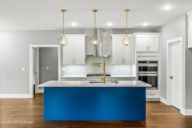 912 Artisan Pkwy, La Grange, KY 40031 - kitchen featuring wall chimney range hood, backsplash, dark wood-type flooring, a center island with sink, and hanging light fixtures