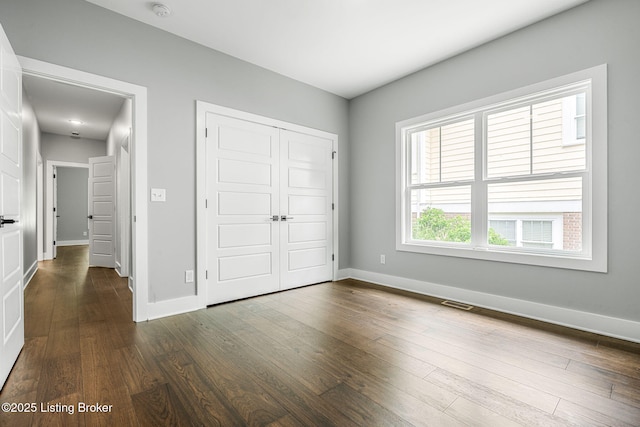 912 Artisan Pkwy, La Grange, KY 40031 - unfurnished bedroom with a closet, dark wood-type flooring, and baseboards