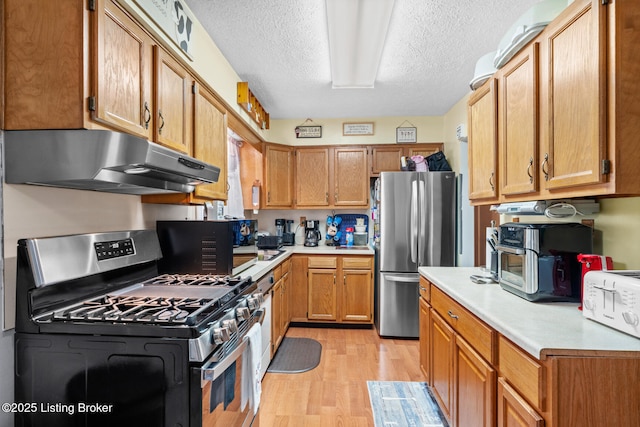 1261 Lipps Ln, Louisville, KY 40219 - kitchen with appliances with stainless steel finishes, under cabinet range hood, light wood-style floors, light countertops, and a textured ceiling