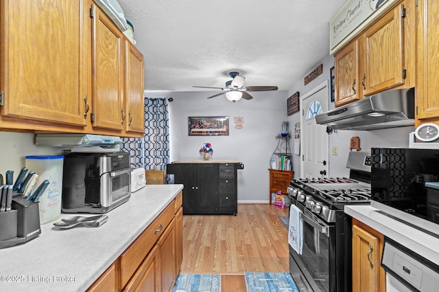 1261 Lipps Ln, Louisville, KY 40219 - kitchen with gas range, under cabinet range hood, light countertops, ceiling fan, and a textured ceiling