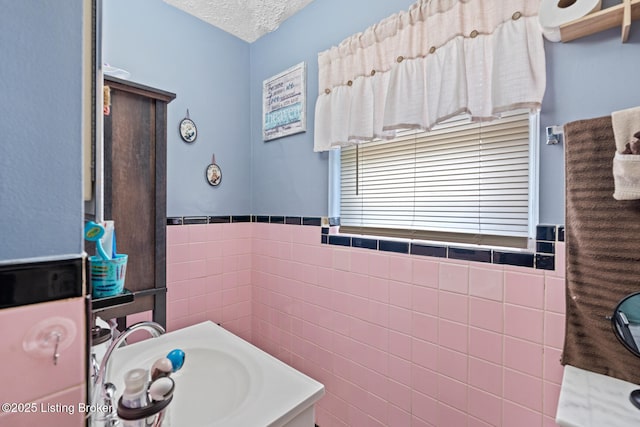 1261 Lipps Ln, Louisville, KY 40219 - bathroom with tile walls, vanity, a textured ceiling, and wainscoting