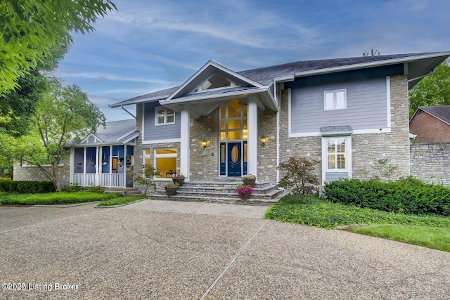 603 Woodlake Dr, Louisville, KY 40245 - view of front of home featuring stone siding, covered porch, and a shingled roof
