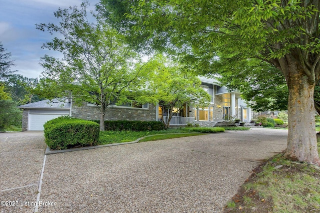 603 Woodlake Dr, Louisville, KY 40245 - view of property hidden behind natural elements with stone siding, a garage, and driveway