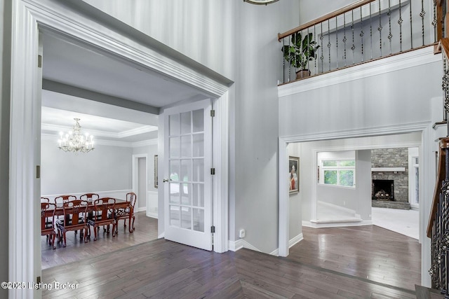 603 Woodlake Dr, Louisville, KY 40245 - entrance foyer with a chandelier, dark wood finished floors, crown molding, a fireplace, and a towering ceiling