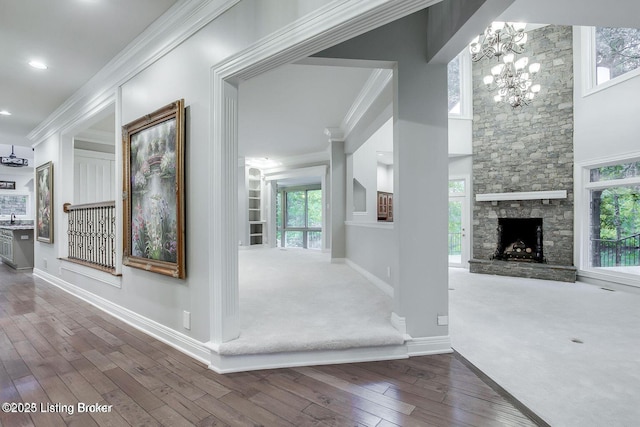 603 Woodlake Dr, Louisville, KY 40245 - corridor with crown molding, baseboards, a chandelier, plenty of natural light, and wood finished floors