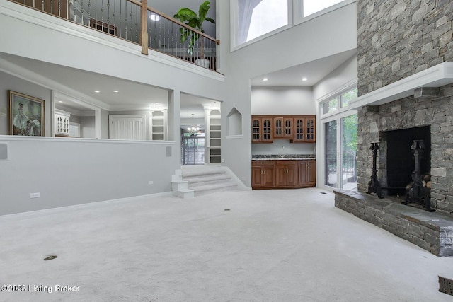 603 Woodlake Dr, Louisville, KY 40245 - unfurnished living room with a towering ceiling, carpet, a sink, a fireplace, and baseboards